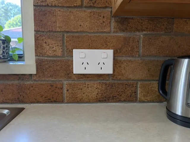 Double power point on a brick kitchen splashback above a benchtop in Meadowbank